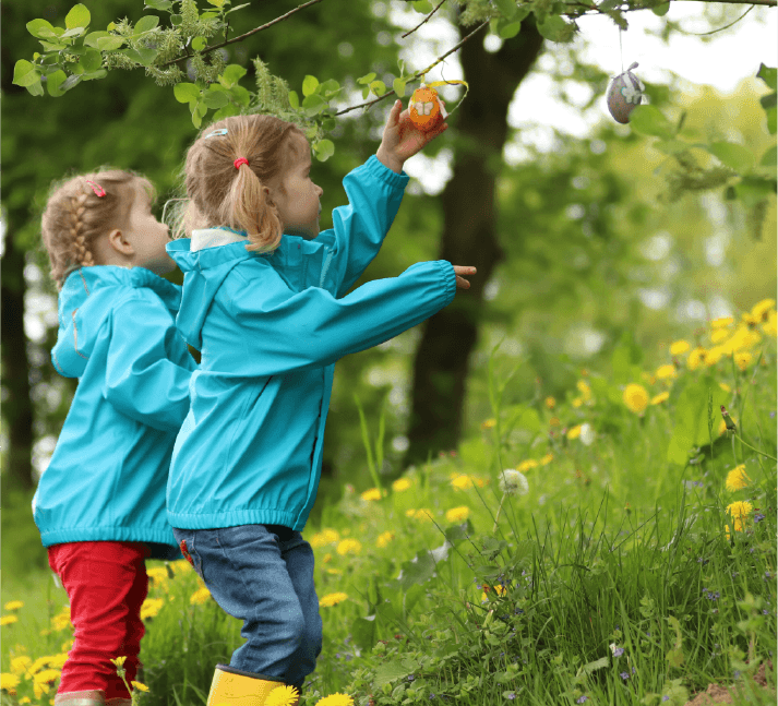 Two young girls, exploring and playing outside in nature.